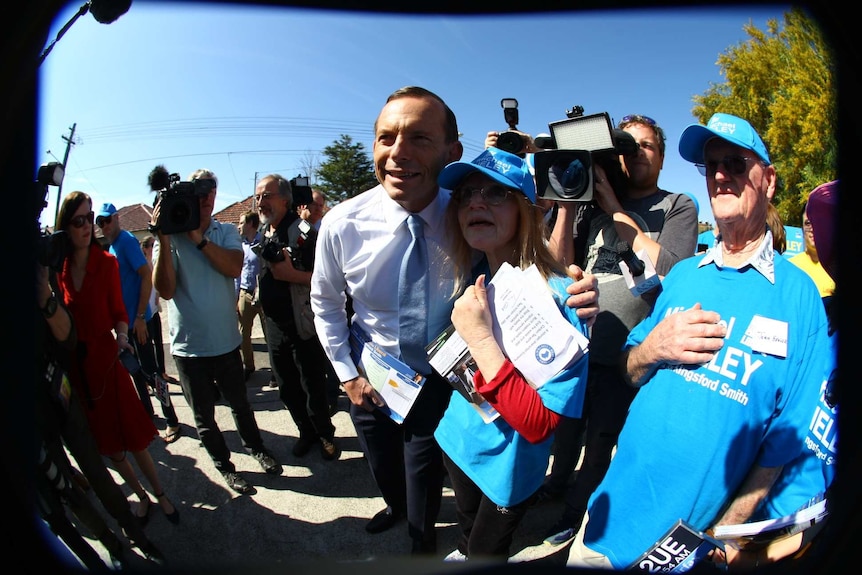 Tony Abbott takes a photo with a female supporter in the electorate of Kingsford Smith on election day