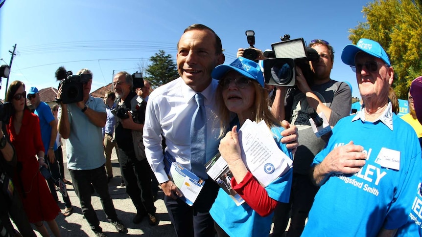 Tony Abbott takes a photo with a female supporter in the electorate of Kingsford Smith on election day