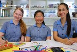 Eloise Holwill, Angela Jia and Zara Mammone sit at a desk in the school science lab.