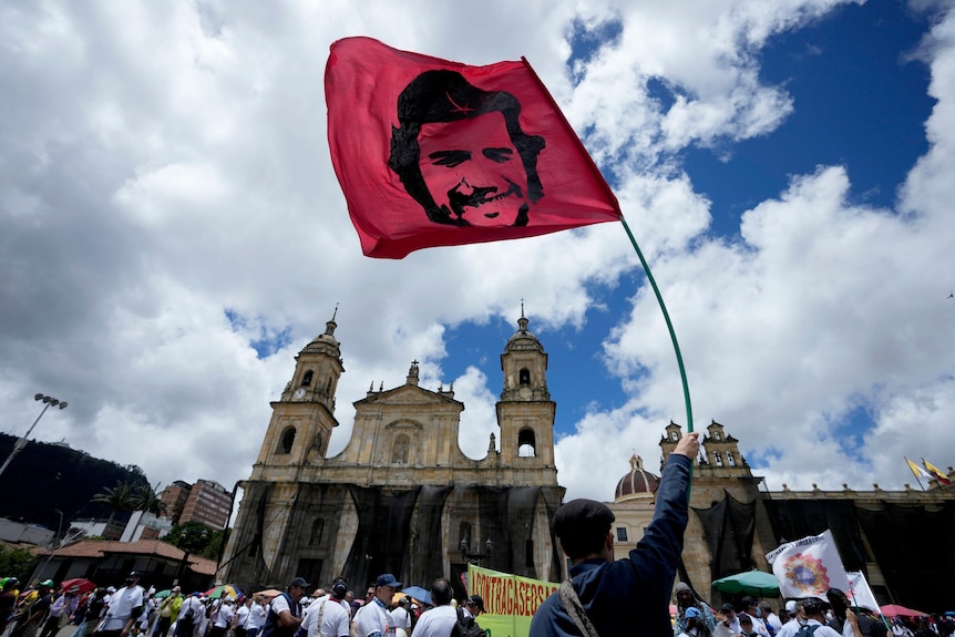 A protester holds a banner with the image of Cuban revolutionary icon