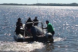 Police divers and officers on board an inflatable rubber dinghy in Leschenault estuary searching, after explosives were found.