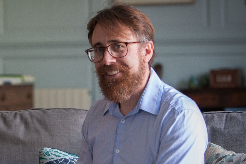 A man wearing a blue collared shirt.