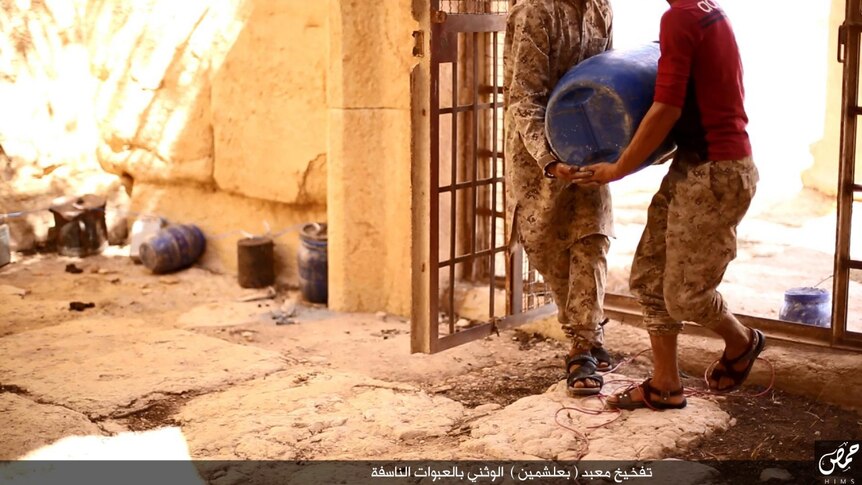 Islamic State militants placing explosive barrels and containers in Palmyra