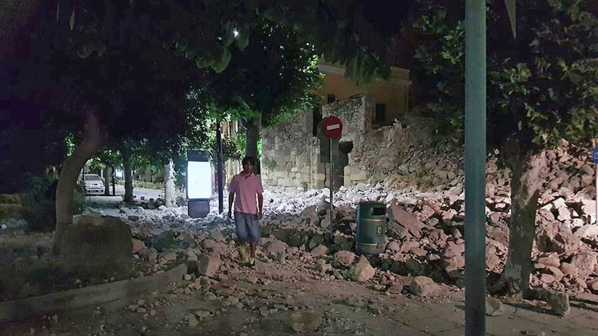 A man stands in rubble from a collapsed building after the earthquake on the island of Kos, Greece.