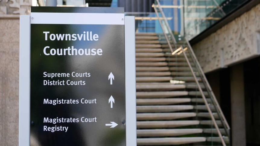 Black Townsville court house sign in front of set of stairs outside of the court house