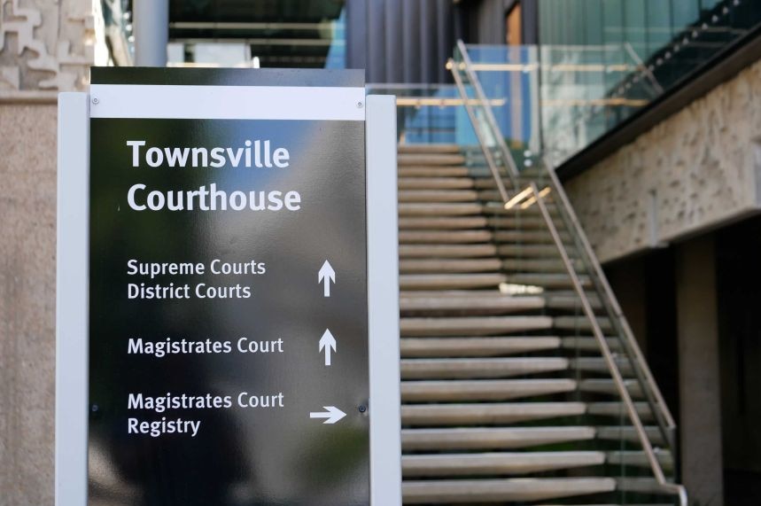 Black Townsville court house sign in front of set of stairs outside of the court house