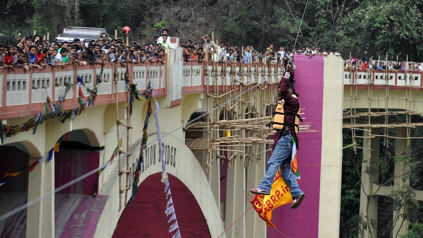 Stuntman attempts river crossing while hanging by ponytail