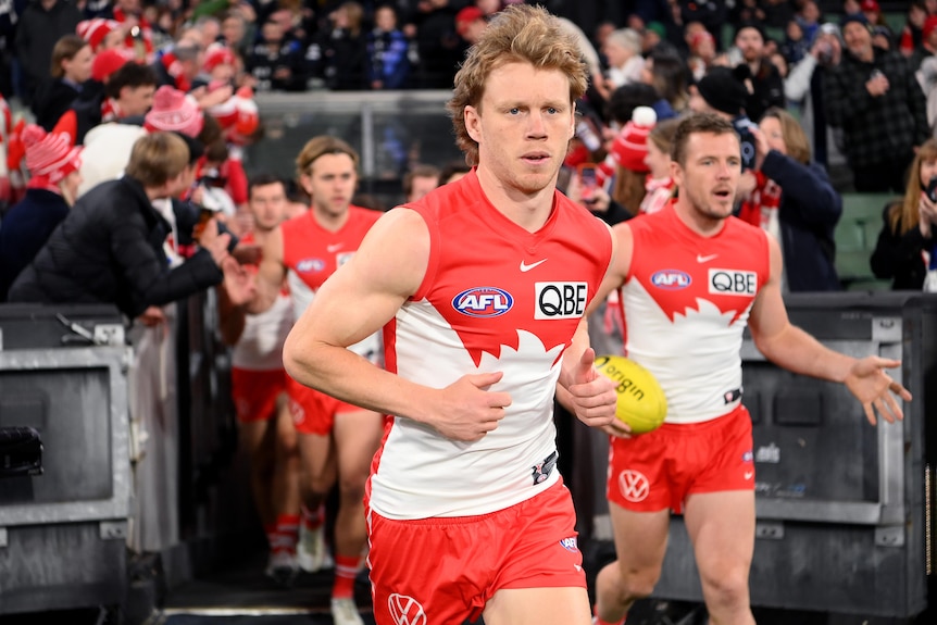 Callum Mills leads out the Sydney Swans