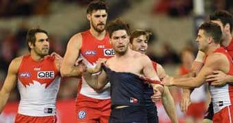 Melbourne Demons player Tom Bugg harassed by Sydney Swans players.