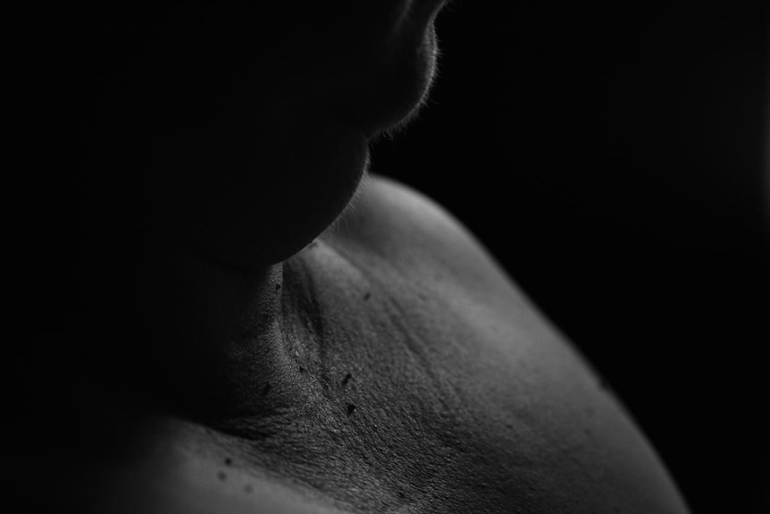 A black and white image of a person's chin and chest