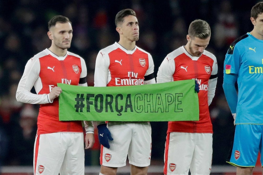 Arsenal defender Gabriel holds a Forca Chape sign
