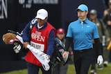 A golfer grimaces as he walks down the first hole on day one of the Open at Royal Portrush.