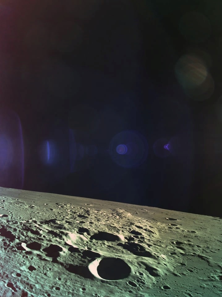 The craters on the surface on the moon can be seen in the foreground while the darkness of space looms in the background.
