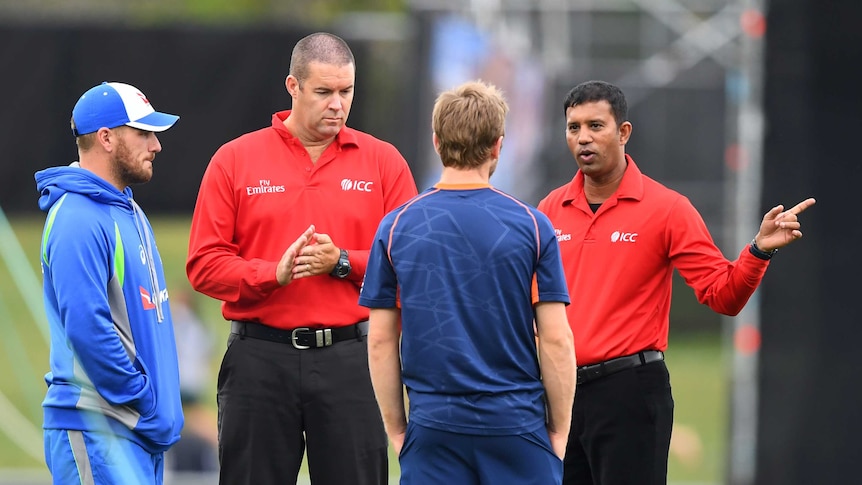 Kane Williamson and Aaron Finch consult with officials in Napier
