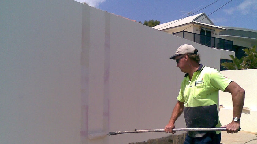 Graffiti sprayed on the front wall of Labor MP John Quigley is cleaned up.