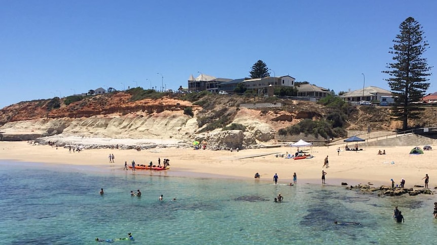 People swimming and snorkelling at the beach in a photo from the water