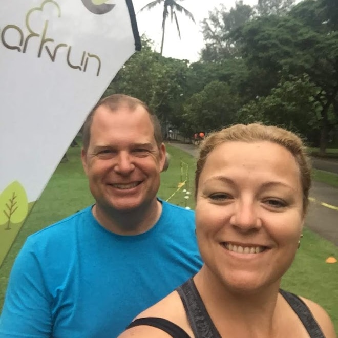 A couple smile at the camera in a selfie in a park