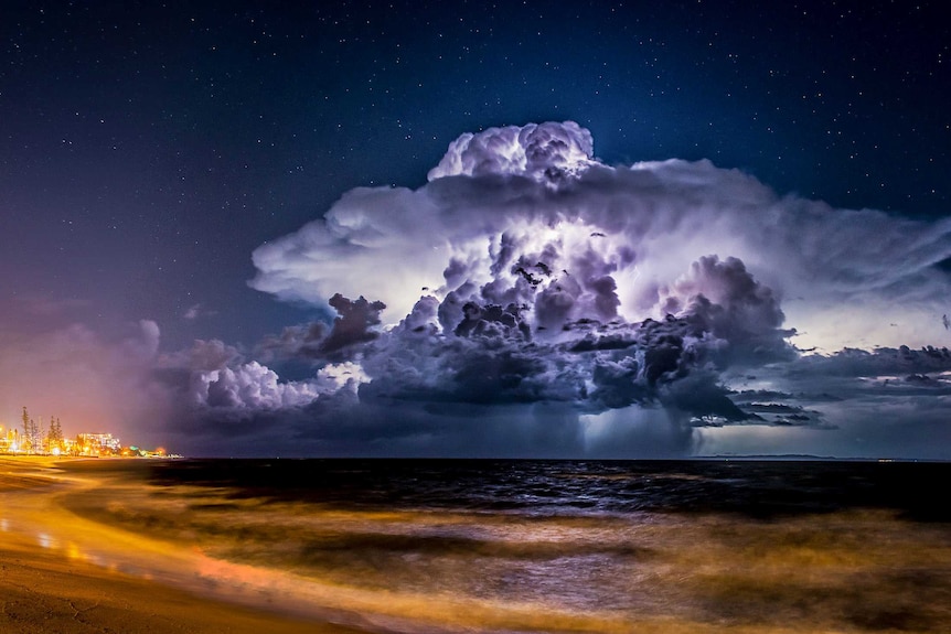 Lightning illuminates a cloud at night as a storm moves out to sea.