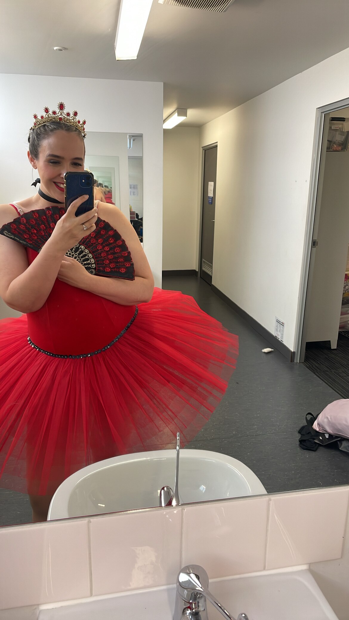Bec Brewin takes a selfie in a change room while wearing a red tutu and tiara for an upcoming ballet performance.