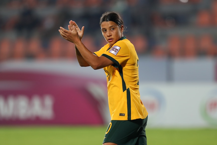 Australian soccer player claps her hands after a match at the Asian Cup