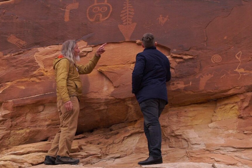 Vaughn Hadendeldt showing ancient rock art to Conor Duffy at Bear's Ears national monument, Utah