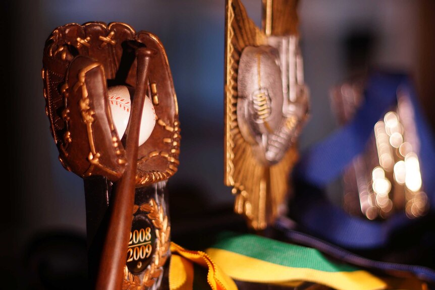 Close up of baseball and football trophies.