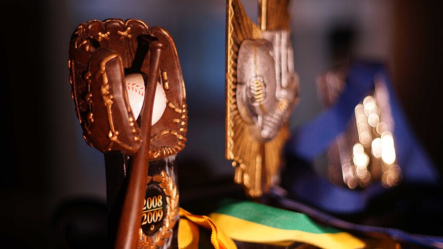 Close up of baseball and football trophies.