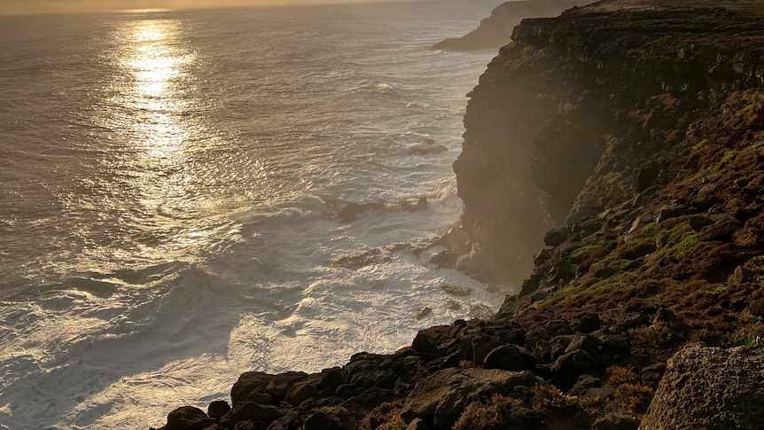 Sunset over cliffs and the ocean.