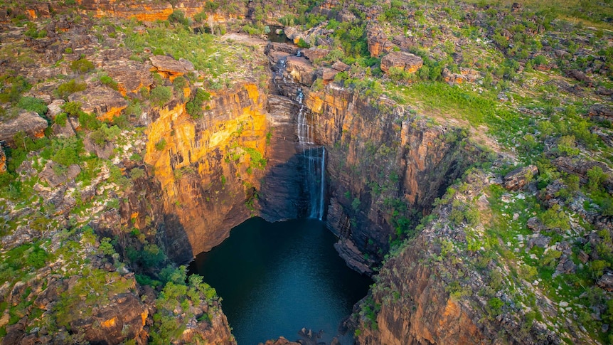 A drone picture of rugged terrain and a waterfall.