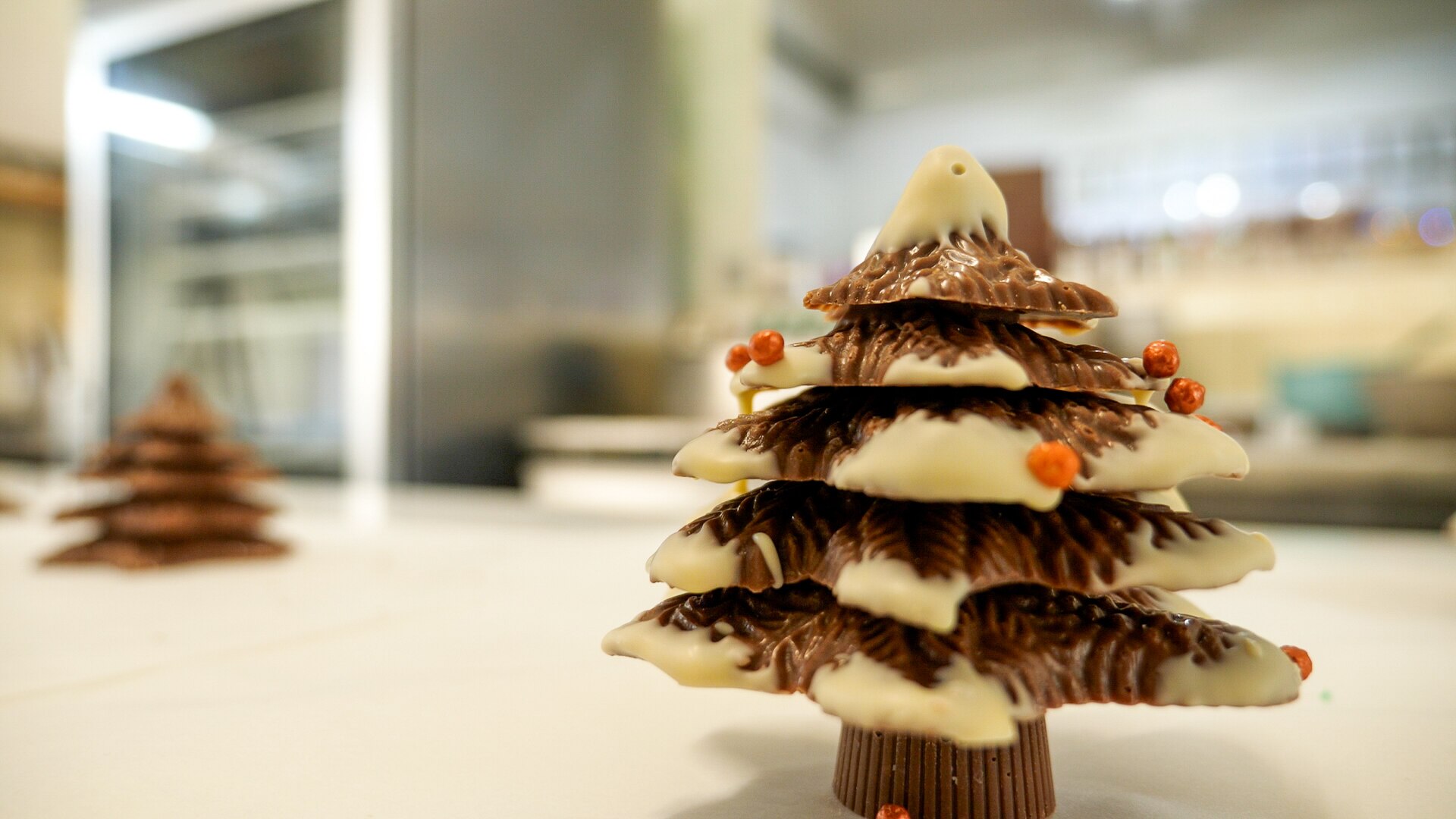 A chocolate Christmas tree is covered in white chocolate and sprinkles. 