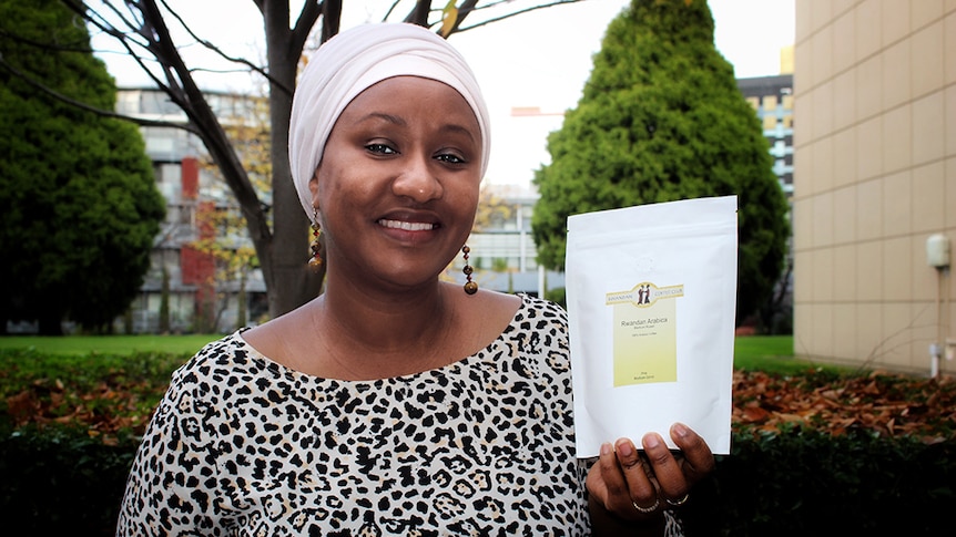 Rwandan woman Faina Illigoga holds a packet of coffee