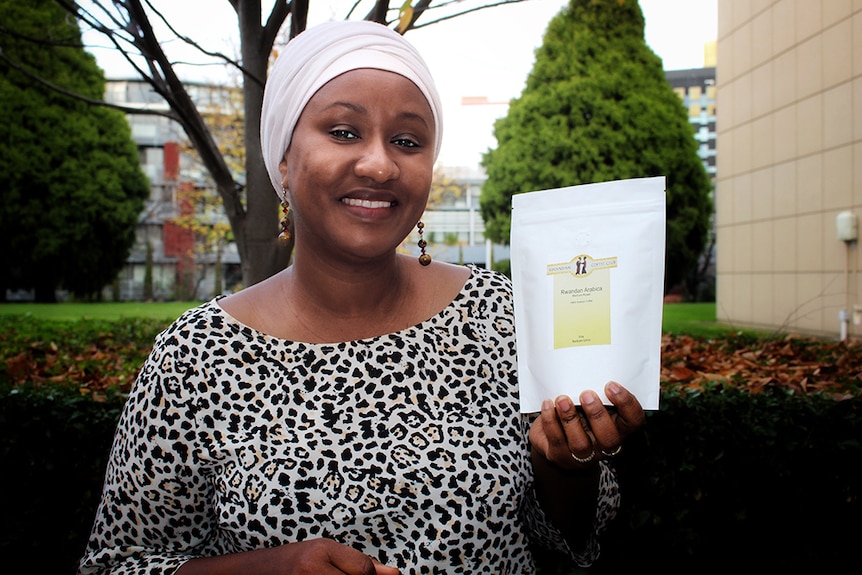 Rwandan woman Faina Illigoga holds a packet of coffee