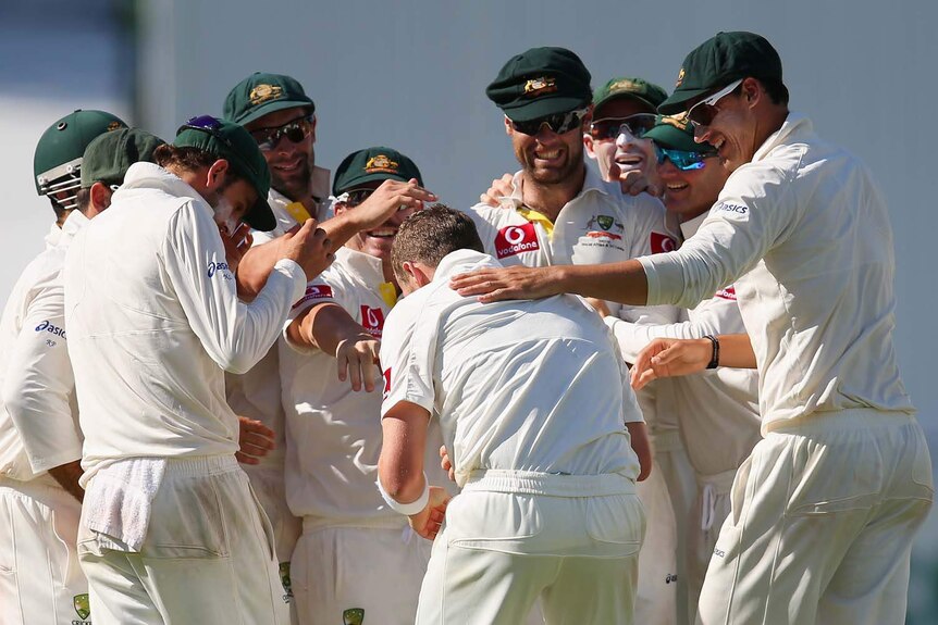 Remarkable effort... an exhausted Peter Siddle is surrounded by team-mates after dismissing Dale Steyn.