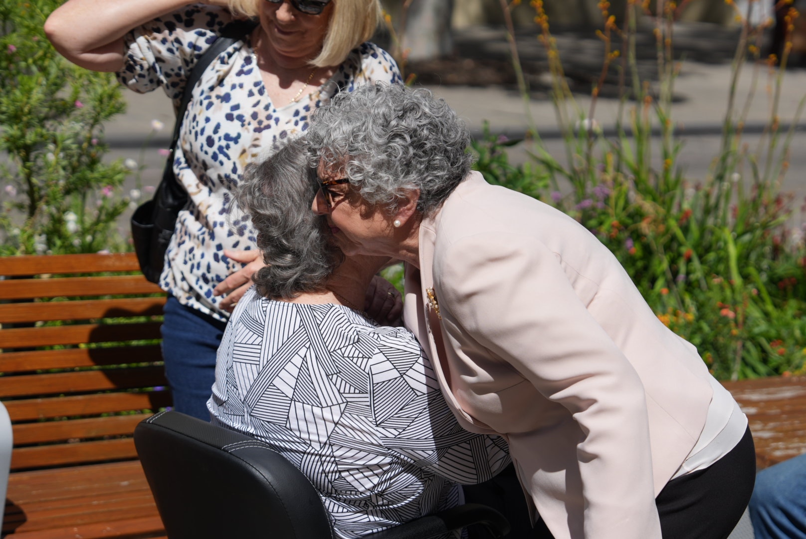 Two women hug outside court