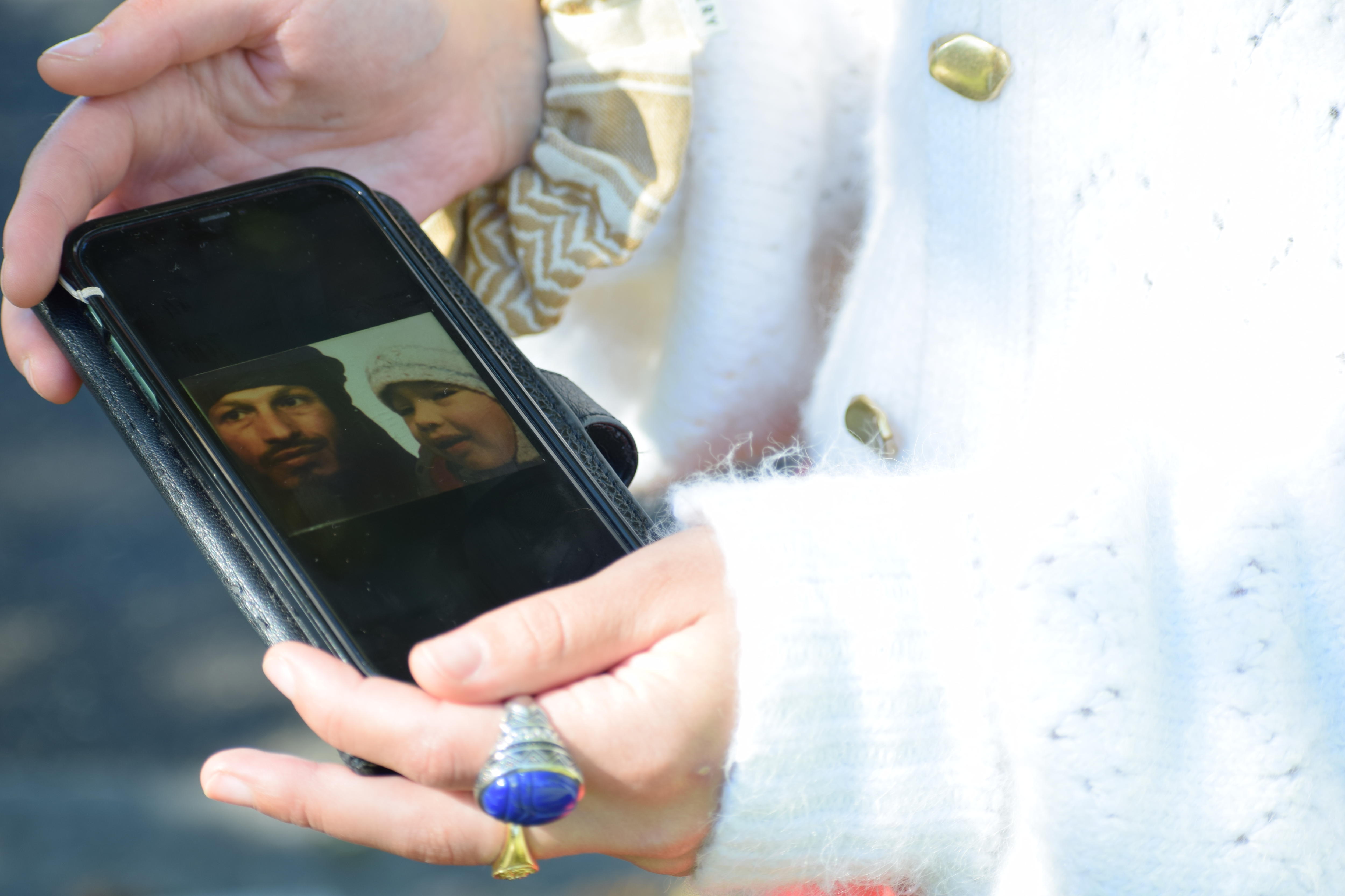 Phone showing passport photo of father and daughter. 