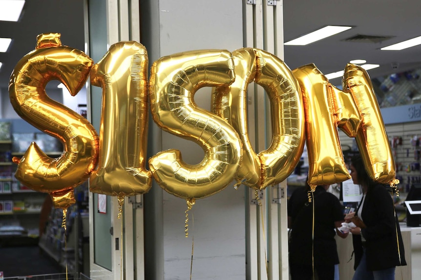 A gold inflatable $150m sign in front of a lotto newsagent.