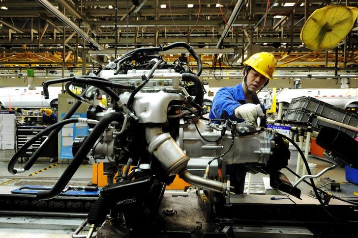 An employee works on a car in China