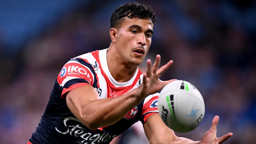 A Sydney Roosters NRL player catches the ball during a warm-up before a match in 2023.