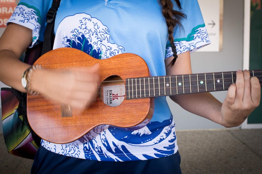 Cara McIlveen from the Ukulele Angels strums her ukulele after a performance at the Cairns Hospital.