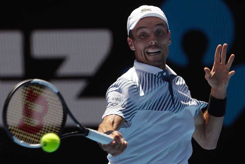 Roberto Bautista Agut grimaces as he plays a forehand against Stefanos Tsitsipas.