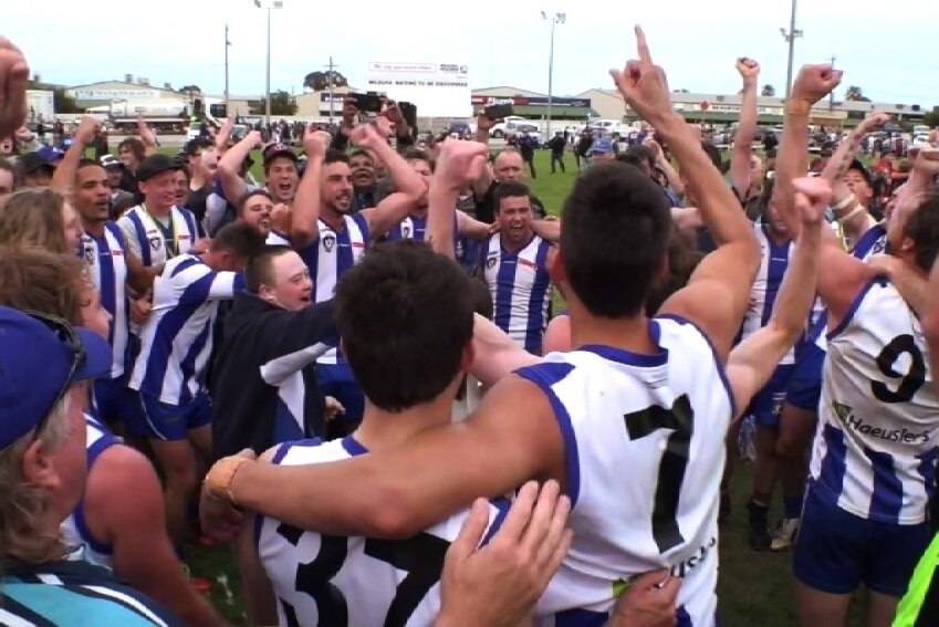 Kangas with arms around each other and arms in the air