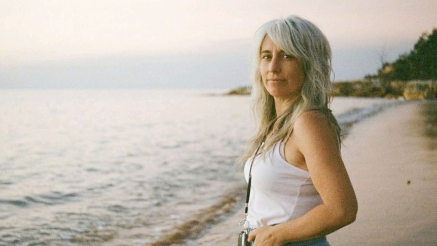 Woman standing on a beach. Low light.