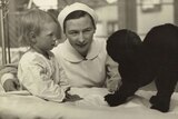 Nurse Kathleen Neuss with a young child and dog.