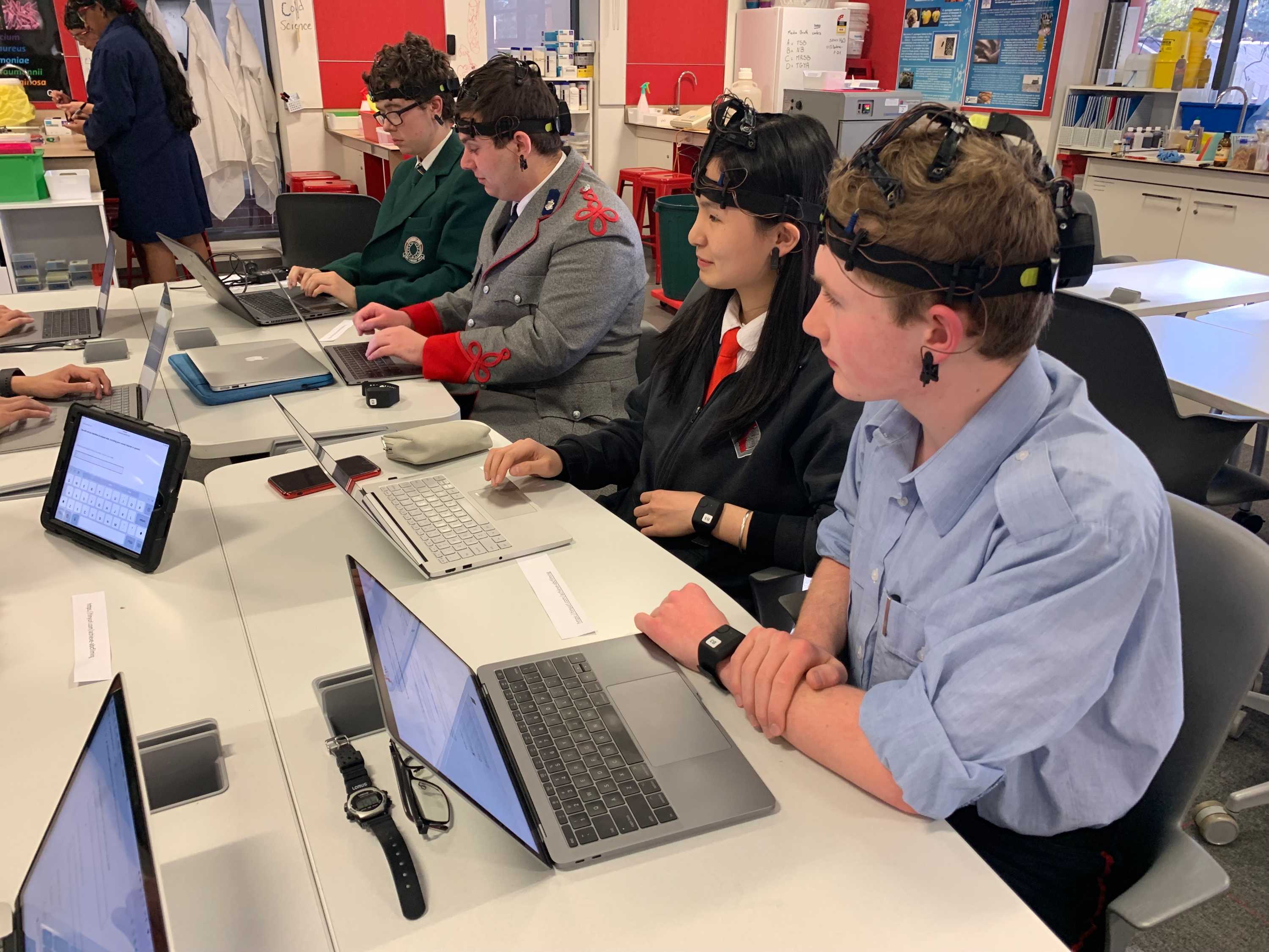 Students wearing ECG headsets while sitting at their computers.