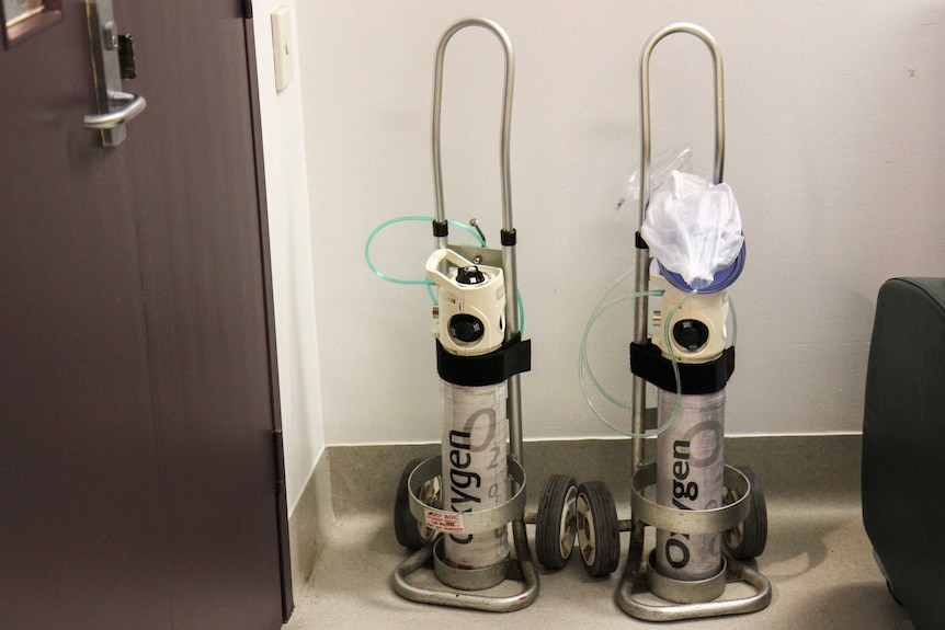 Oxygen tanks next to a wall. 