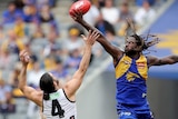 Nic Naitanui leaps higher than Brodie Grundy at a centre bouncedown and wins the tap