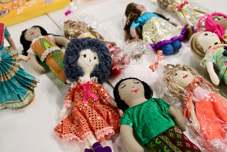 A group of fabric dolls laying on a table.