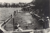 Black-and-white image of a swimming pool with people in Sydney Harbour.