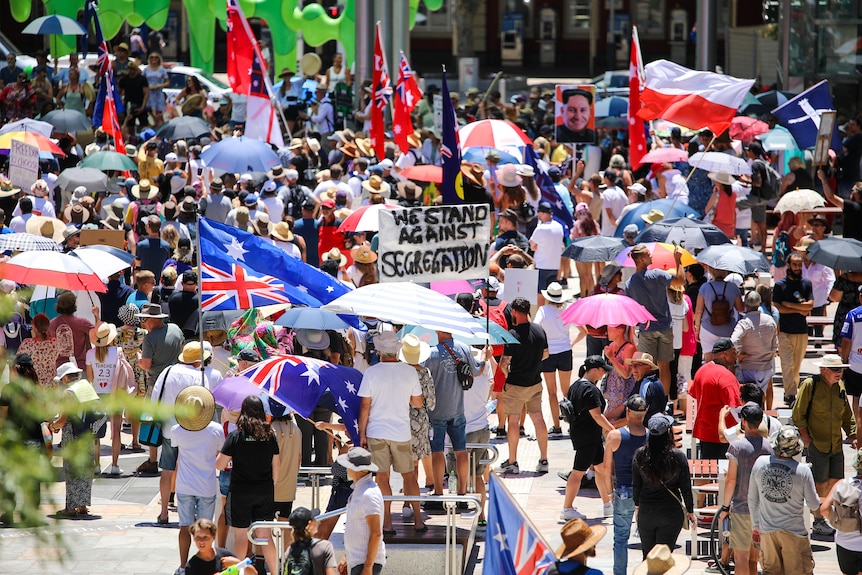 A few thousand people carrying signs, flags and umbrellas gather for a freedom rally in Perth.