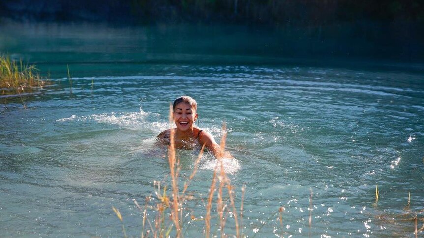 Mia Ayliffe-Chung laughing and swimming in a lake in a Facebook photo.